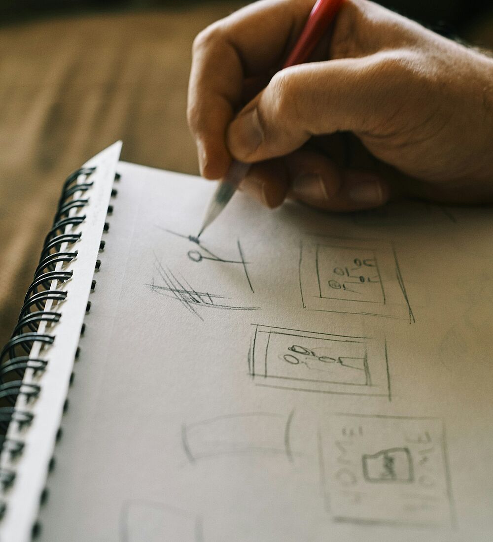 Eine Hand schreibt mit Stift in ein Notizbuch